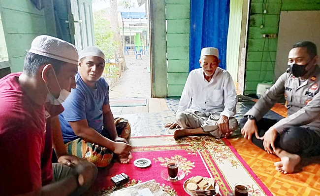 Kapolsek Kelumpang Selatan Kabupaten Kotabaru bersama para panitia Haul Datuk Kelampayan di Desa Pantai saat berdiskusi (Sumber Foto: istimewa/koranbanjar.net)