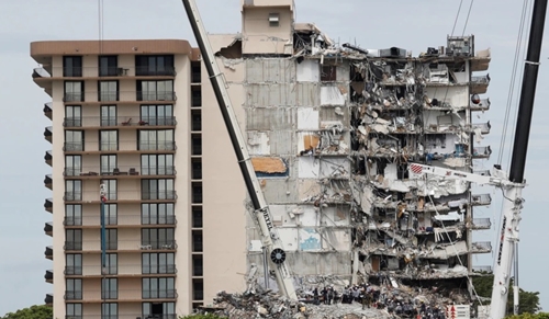 Petugas darurat melakukan upaya pencarian dan penyelamatan di lokasi bangunan tempat tinggal yang sebagian runtuh di Surfside, dekat Miami Beach, Florida, AS, 29 Juni 2021. (Foto: REUTERS/Joe Skipper)