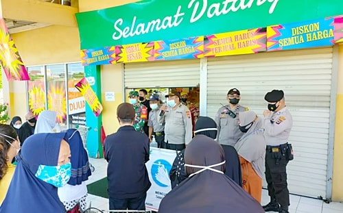 Petugas imbau pelanggan Gaint yang memburu obral murah. (Foto:ist)