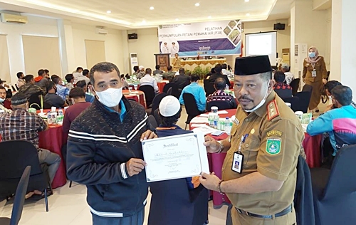 Di sela Pelatihan Perkumpulan Petani Pemakai Air (P3A) Kadis PUPR menyempatkan foto sertifikat di belakang puluhan peserta pelatihan.(Foto: Subhansyah)