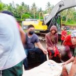 Tim penyelamat duduk di samping kantong mayat yang berisi jenazah seorang korban sipil ketika sebuah pesawat militer C-130 Filipina jatuh di kota Patikul, provinsi Sulu, Filipina selatan pada 4 Juli 2021. (Foto: AP)