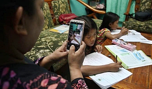 Ilustrasi seorang ibu mendampingi anak belajar online akibat kebijakan PPKM.(foto: ist)