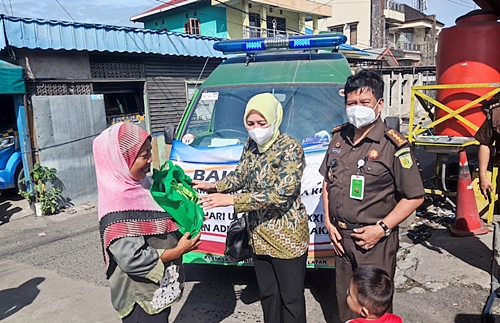 Asisten Intelijen(Asintel) Abdul Rahman bersama staf jajaran membagikan sembako kepada masyarakat tidak mampu yang berada di pinggir jalan.(foto: leon)