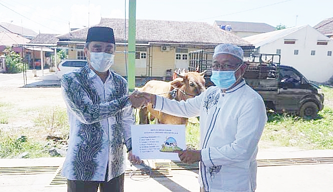 Sandiaga Uno menyerahkan bantuan hewan kurban secara simbolis kepada salah satu warga Sekumpul.(foto: ist)