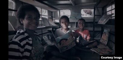 Anak-anak di Papua membaca di mobil pustaka "Sahabat Anak". (Foto WVI)