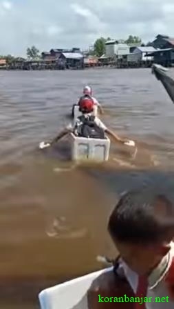 BOCAH SD - Ketiga bocah SD sedang menyeberangi sungai dengan kardus busa. (foto: tangkapan layar video)