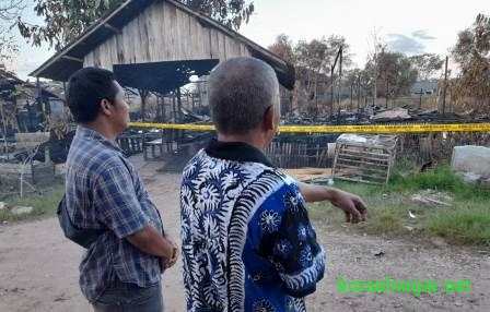 Tri dan Heri hanya memandang puing - puing banguan rumah mereka yang terbakar dengan raut wajah sedih.(foto: leon)