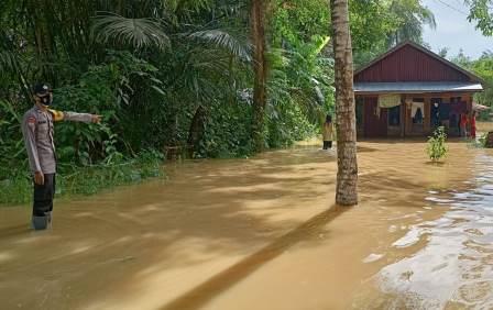 Petugas polsek Banua Lawas melakukan monitoring ke rumah warga yang terdampak banjir. (foto: Polsek Banua Lawas)