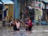 Sebuah keluarga mengarungi jalan yang tergenang banjir di Chennai, India, Rabu, 25 November 2020. Pada 19 November 2021, pihak berwenang negara bagian Andhra Pradesh, India mengatakan sedikitnya 17 orang tewas dan puluhan dilaporkan hilang setelah hujan lebat. (Foto: AP)