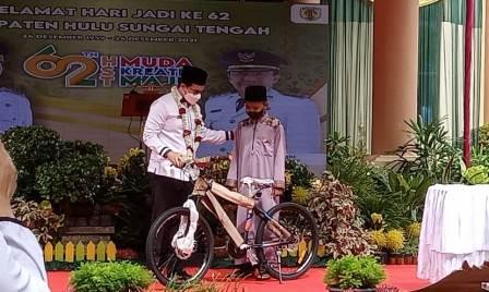 HADIAH – Bupati HST menyerahkan bantuan sepeda kepada Muhajir.