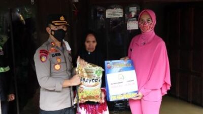 Kapolres Tabalong AKBP Riza Muttaqin didampingi Ketua Bhayangkari Tabalong Ny Susi Muttaqin menyerahkan bantuan sembako kepada warga terdampak banjir. (foto : humas polres tabalong)