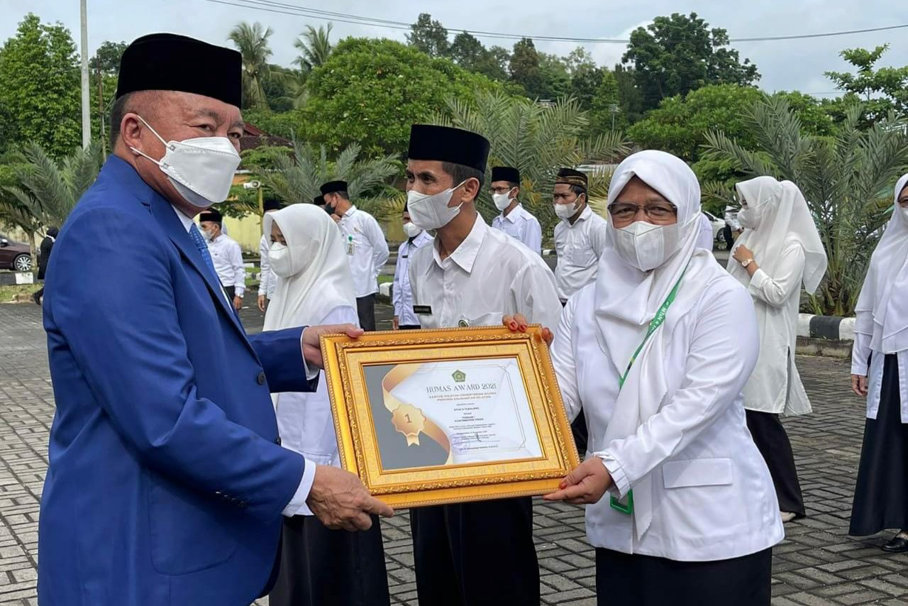 Wakil Gubernur Kalsel, H Muhidin menyerahkan penghargaan Humas Award kepada Kepala MTsN 4 Tabalong. (foto : humas MTsN 4 Tabalong)