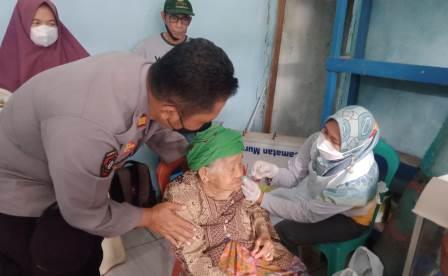 Kapolsek Murung Pudak, AKP Samsu Suargana mendapingi seorang nenek renta yang ingin divaksin (foto : polsek murung pudak)
