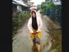 Warga Gang Ruhuy Rahayu berada di tengah banjir.