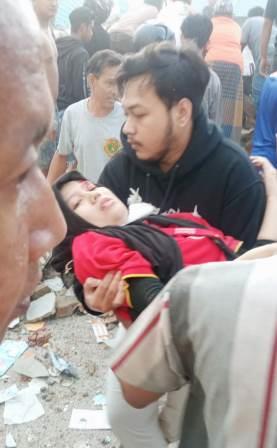 Relawan memberikan pertolongan kepada seorang karyawati Alfamart yang ditemukan terjepit di antara reruntuhan bangunan Alfamart. 