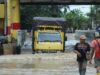 Syamsudin, supir truk asal banjarmasin sedang memperbaiki truknya yang mogok akibat menerobos banjir. (Foto: Arif/Koranbanjar.net)