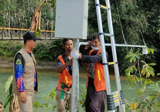 Anggota BPBD Kabupaten HST melakukan pemasangan EWS untuk pantau perkembangan aliran sungai di desa Alat Kecamatan Hantakan (Foto: Adi Yufa/Koranbanjar.net)