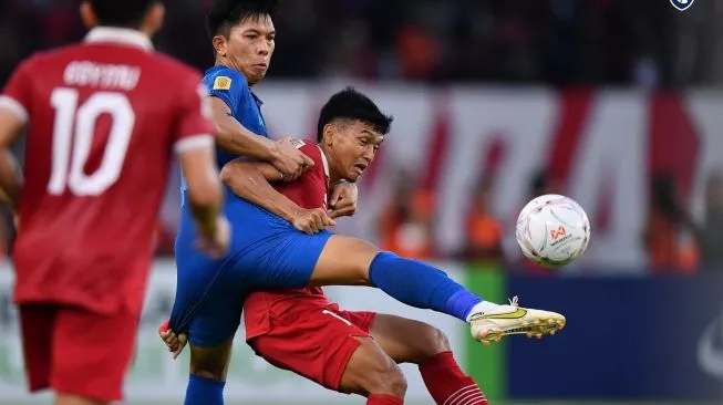 Striker Timnas Indonesia, Dendy Sulistyawan berebut bola dengan pemain Thailand dalam laga ketiga Grup A Piala AFF 2022 di Stadion Utama Gelora Bung Karno (SUGBK), Senayan, Jakarta, Kamis (29/12/2022). (Sumber Foto: Twitter/@Changsuek_th)