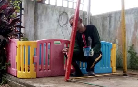 Khairuddin tengah memperbaharui sarana bermain anak. (Foto: Koranbanjar.net)