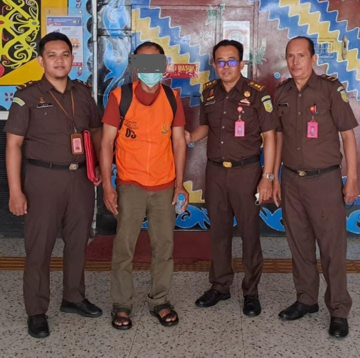 Tersangka H (rompi orange) diapit Penyidik Pidsus Kejati Kalsel di Kantor Kejati Kalsel Banjarmasin, Rabu (8/2/2023). (Foto: Koranbanjar.net)