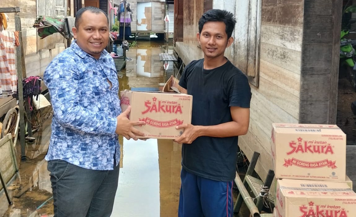 Anggota DPRD Kabupaten Banjar, Rahmat Saleh secara simbolis menyerahkan bantuan sembkao kepada warga terdampak banjir, di Jalan Melati RT 01 Desa Bincau, Kecamatan Martapura, Selasa (7/3/2023). (Foto: Redaksi8.com)