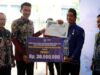 Bupati Banjar H Saidi Mansyur menyerahkan hadiah juara I kepada Desa Indrasari Kecamatan Martapura sebagai pemenang lomba desa tingkat Kabupaten Banjar tahun 2023, di halaman Mahligai Sultan Adam Martapura, Kamis (15/6/2023) pagi. (Sumber Foto: Kominfo Kabupaten Banjar/Koranbanjar.net)