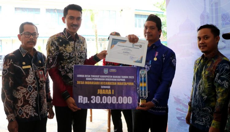 Bupati Banjar H Saidi Mansyur menyerahkan hadiah juara I kepada Desa Indrasari Kecamatan Martapura sebagai pemenang lomba desa tingkat Kabupaten Banjar tahun 2023, di halaman Mahligai Sultan Adam Martapura, Kamis (15/6/2023) pagi. (Sumber Foto: Kominfo Kabupaten Banjar/Koranbanjar.net)