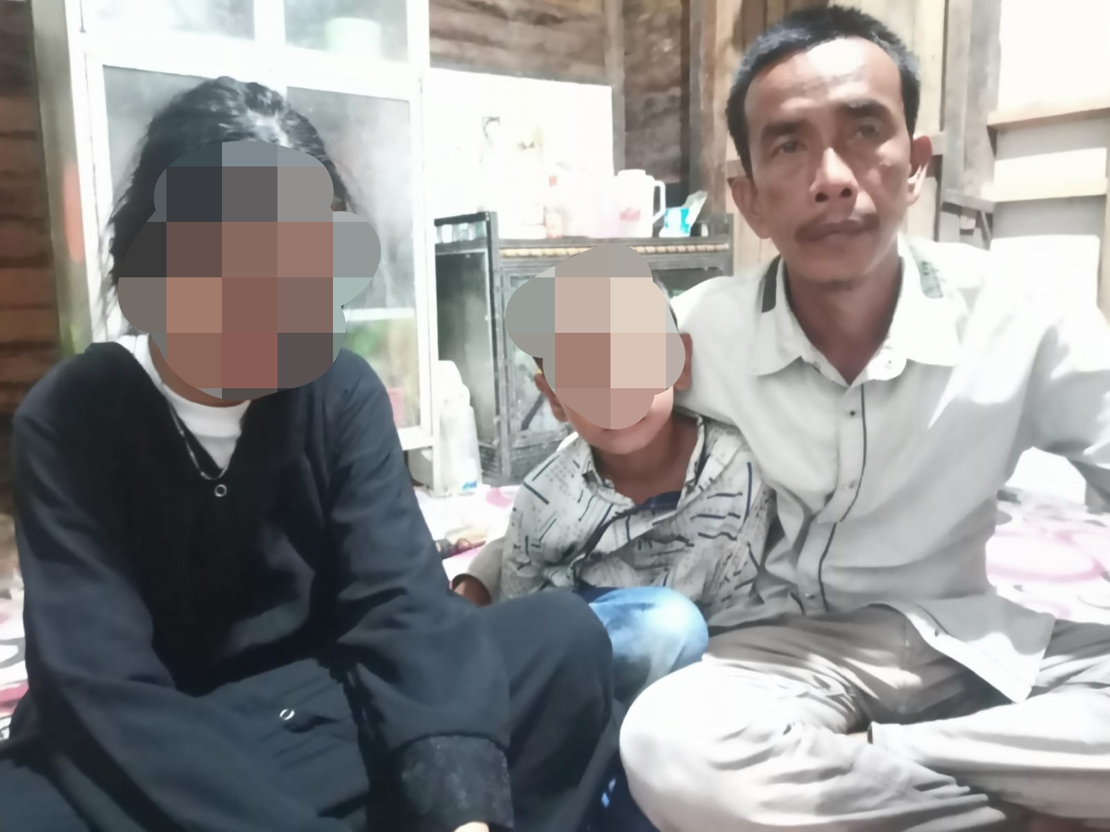 Hasan bersama kedua anaknya menanti kepulangan Yuli. Rumah Hasan Jalan Alalak Tengah Banjarmasin, Senin (10/7/2023). (Foto: Koranbanjar.net)