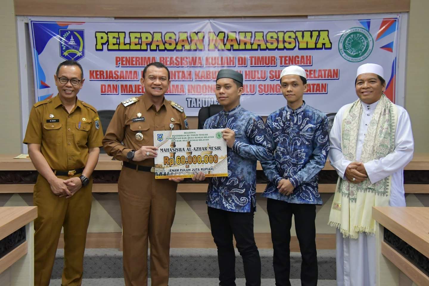Pj Bupati HSS Hermansyah menyerahkan dana beasiswa secara simbolis untuk pendidikan tinggi ke Timur Tengah, Selasa (24/10/2023). (Foto: Prokopim HSS/Koranbanjar.net)
