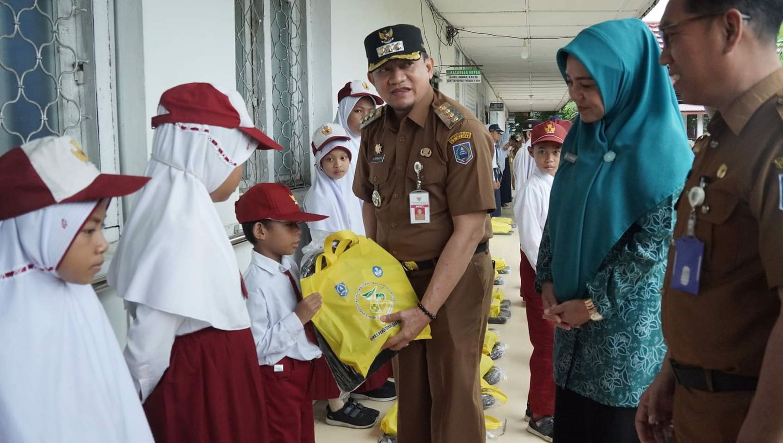 Pj Bupati HSS Hermansyah menyerahkan bantuan perlengkapan sekolah bagi pelajar SD, SMP serta Paket A, B, dan C, Senin (4/12/2023). (Foto: Prokopim HSS/Koranbanjar.net)