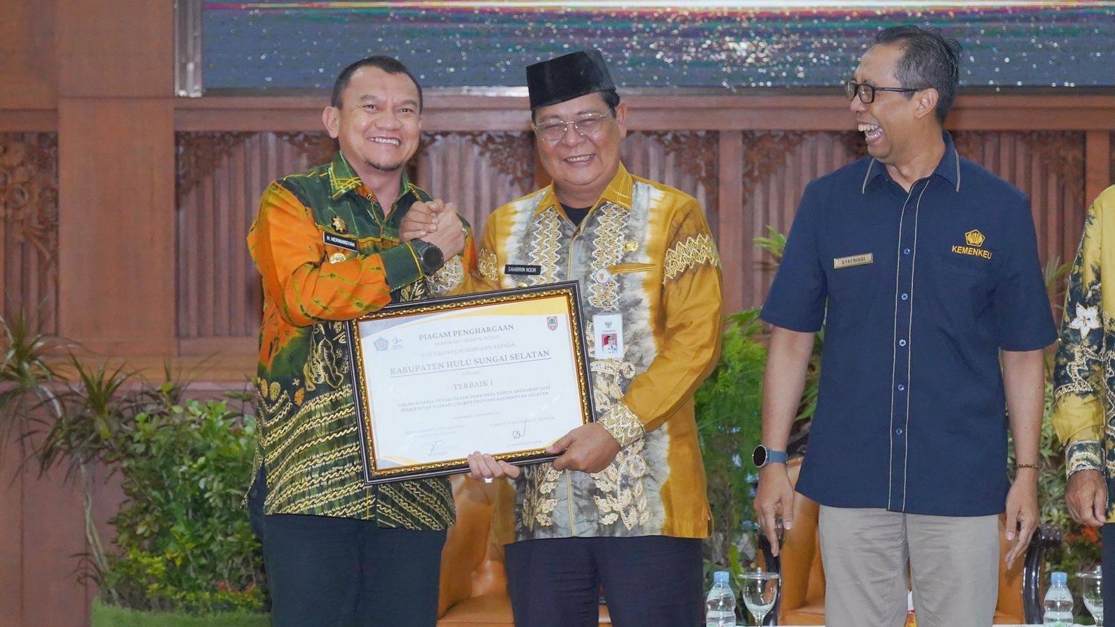 Pj Bupati HSS Hermansyah (kiri) menerima piagam penghargaan dari Gubernur Kalsel Sahbirin Noor (tengah), Jumat (1/12/2023) pagi. (Foto: Prokopim HSS/Koranbanjar.net)