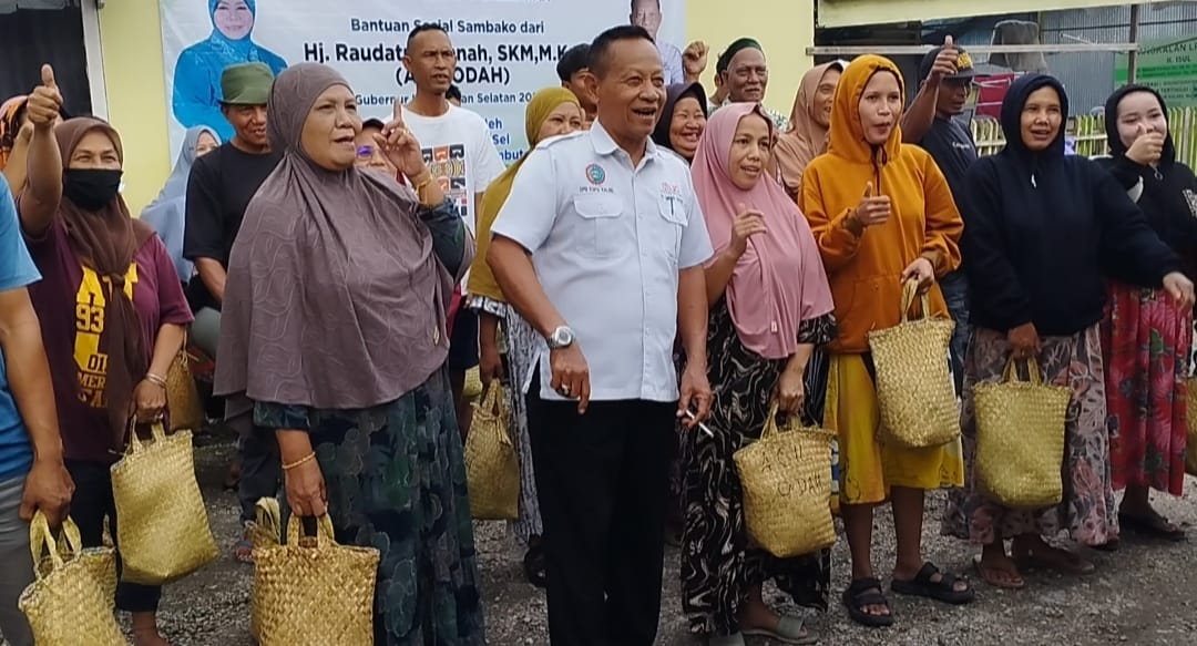 Ketua DPD KSPSI Provinsi Kalimantan Selatan, Haji Sadin Sasau (putih tengah) bersama warga Mantuil penerima sembako, Rabu (3/7/2024). (Foto: Leon/Koranbanjar.net)