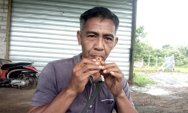 Gajali Rahman saat memperagakan meniup bambu untuk memanggil burung. (foto: koranbanjar.net)