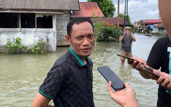 Pembakal (Kepala) Desa Kelampayan Tengah, Rusdian, di lokasi banjir.